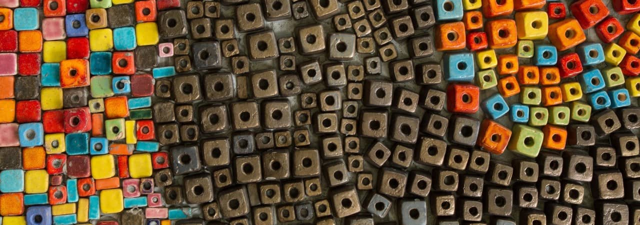 verschiedenfarbige, holzigfarbene Perlen. In der Mitte ist eine Art Fluss von geordneten braunen Perlen.